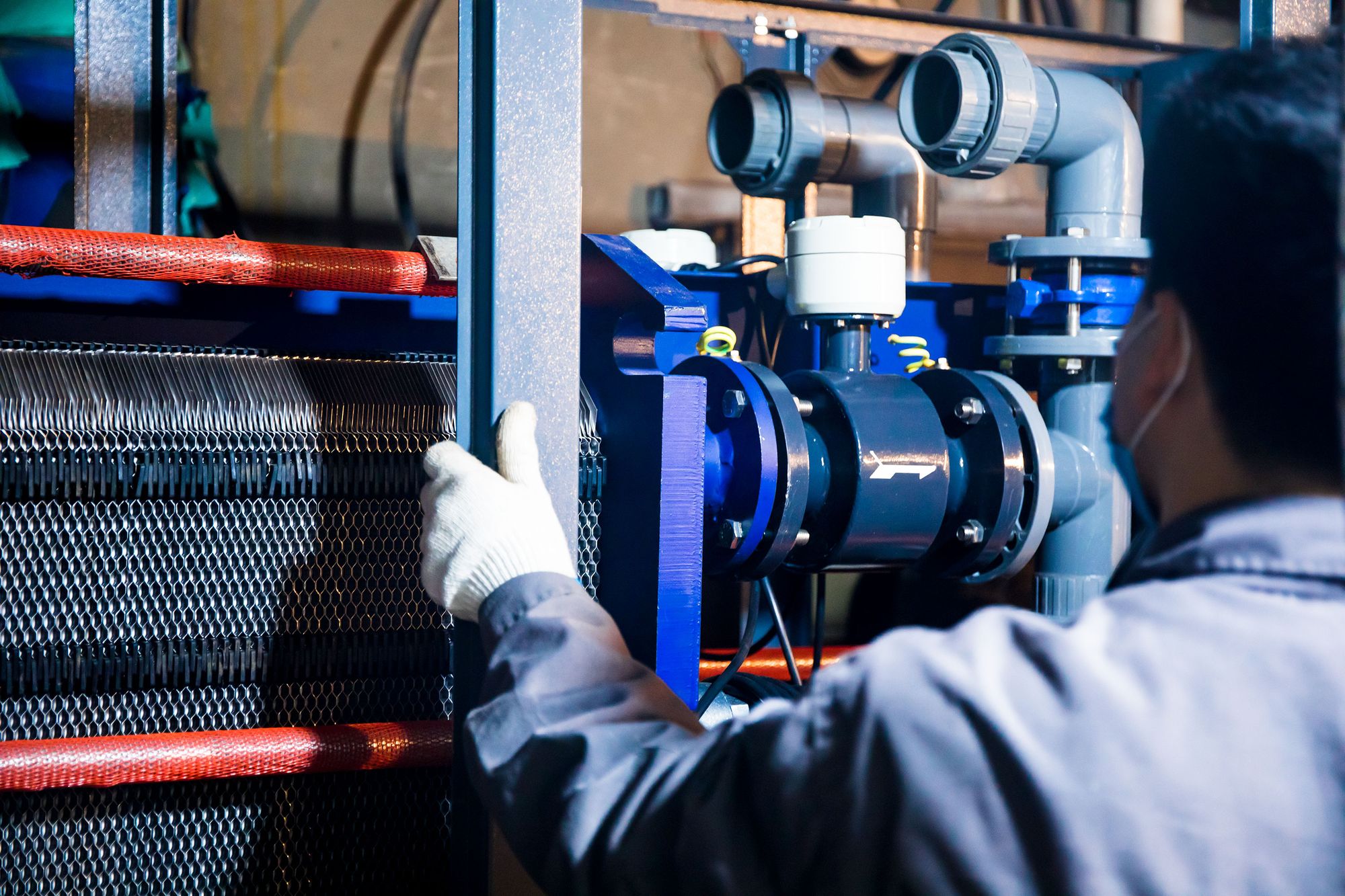 Worker reviewing industrial piping and equipment